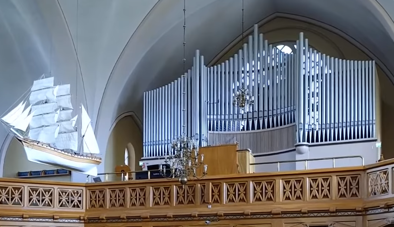 Interno della chiesa di Kemi con una barca sospesa e organo.