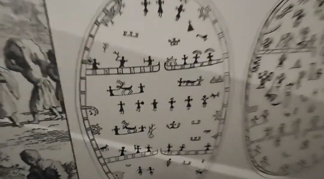 Dettagli di antichi disegni su una superficie ovale raffiguranti figure stilizzate Sami.
