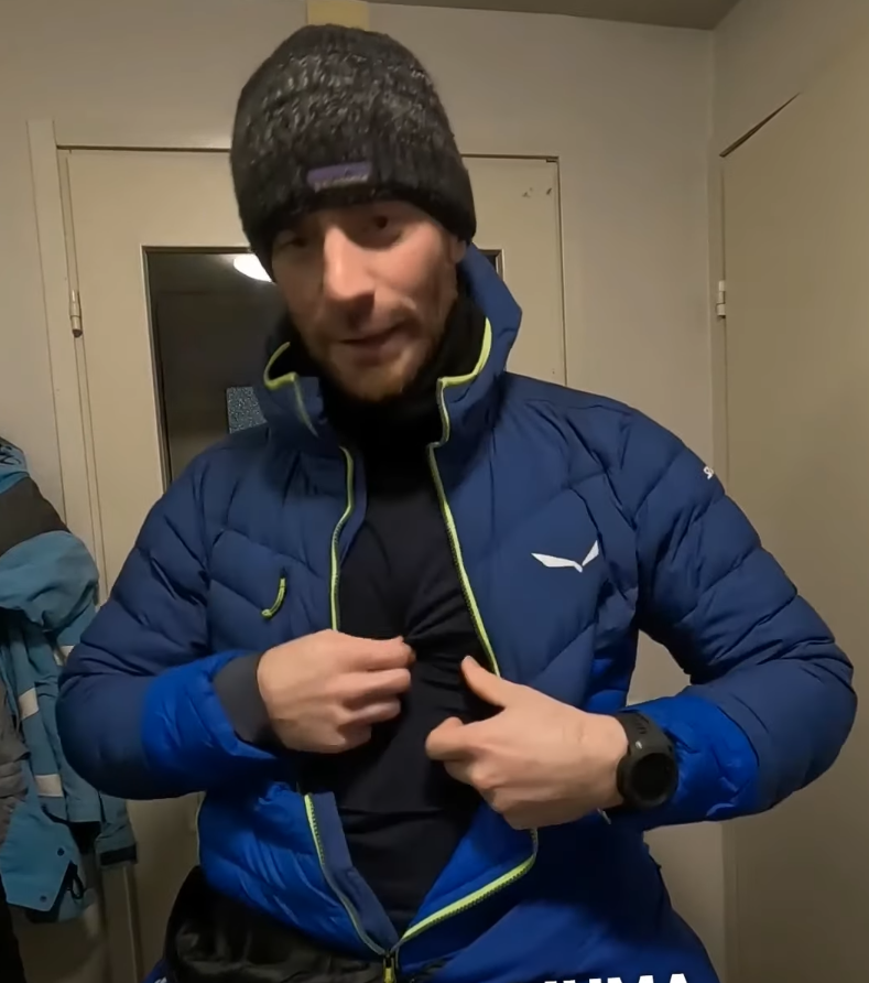 Stefano Mini mostra la sua giacca blu Salewa e il primo strato nero, evidenziando l'abbigliamento tecnico per l'outdoor.