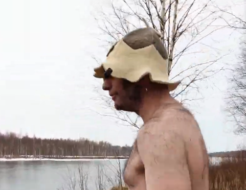 Stefano Mini con cappello da sauna vicino a un lago ghiacciato in inverno.