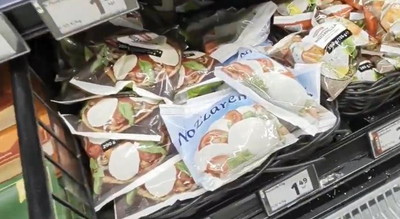 Mozzarella fresca confezionata in buste trasparenti, esposta in un banco frigo di supermercato con etichette dei prezzi.