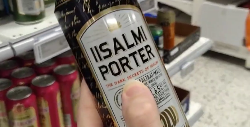 Una mano tiene una lattina di birra Iisalmi Porter con la scritta "The Dark Secrets of Iisalmi" in un supermercato.