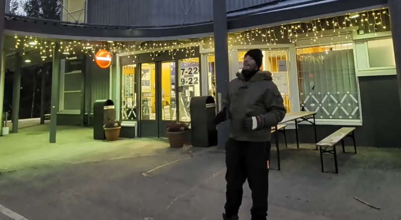 Stefano Mini di fronte a un supermercato K-market di sera.