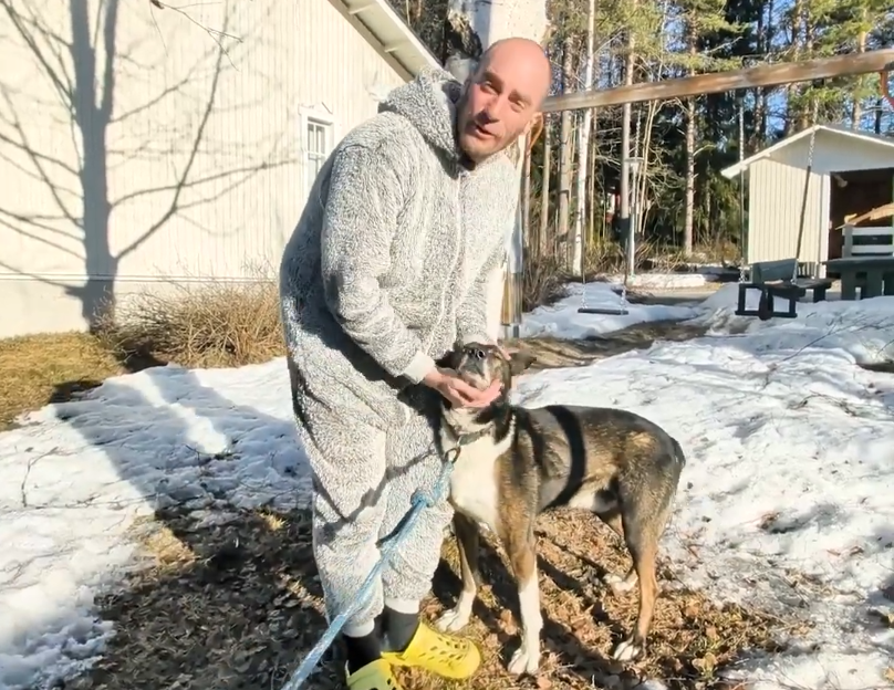 Stefano accarezza un alaskan husky in giardino.