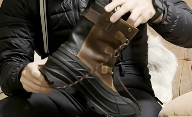 Stefano Mini tiene in mano uno stivale invernale marrone e nero di marca Kamik.